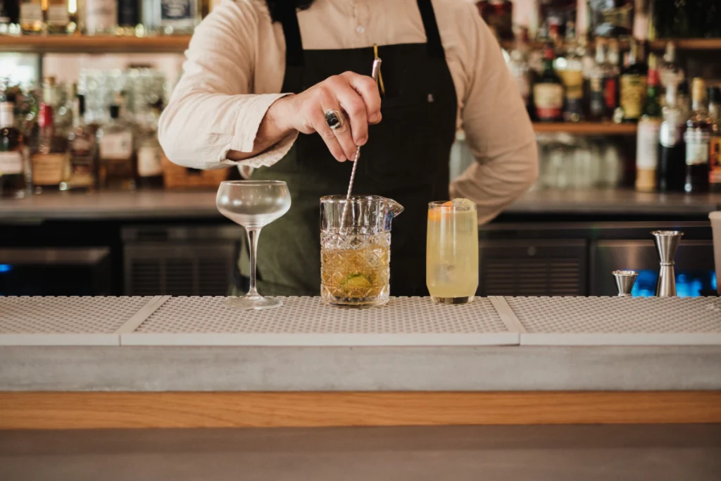 Bartender preparing a drink with extra virgin olive oil using mixology techniques