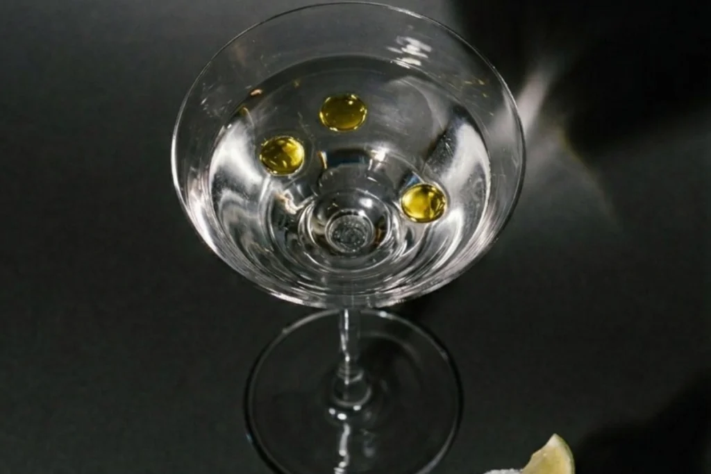Fat-washed Martini cocktail with extra virgin olive oil droplets in mixology